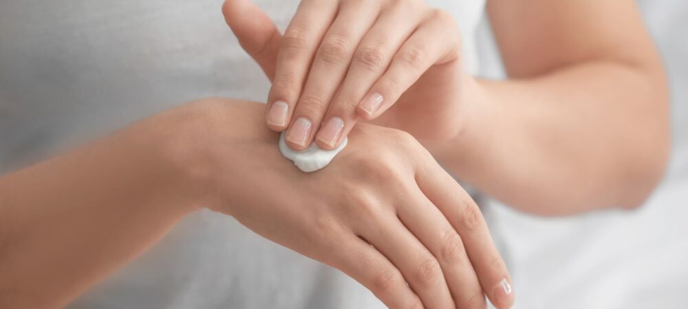 Vrouw smeert handcrème op handen