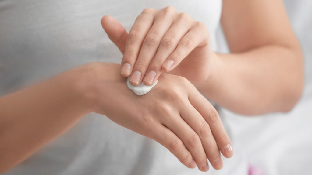 Vrouw smeert handcrème op handen